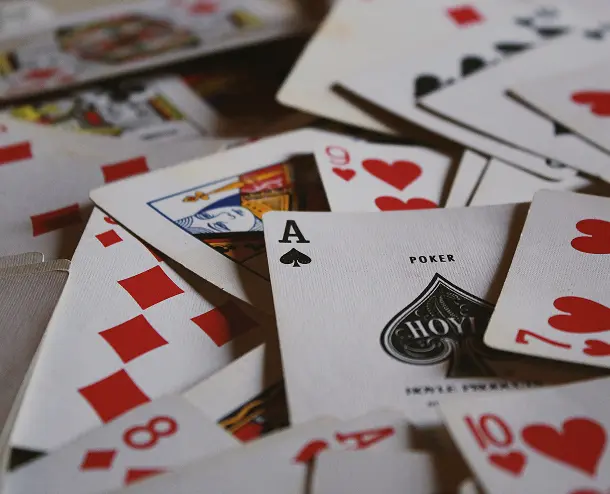A close-up of various playing cards spread out on a table Scattered playing cards on a table
